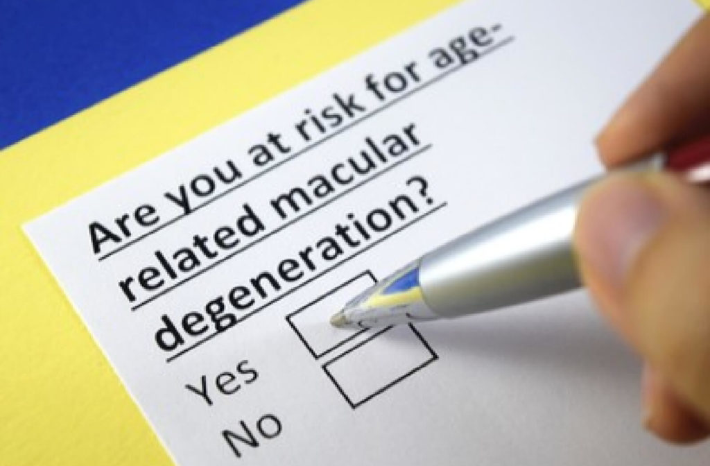 A close-up of a hand holding a pen and marking a checklist on a question that is asking if you are at risk of age-related macular degeneration.