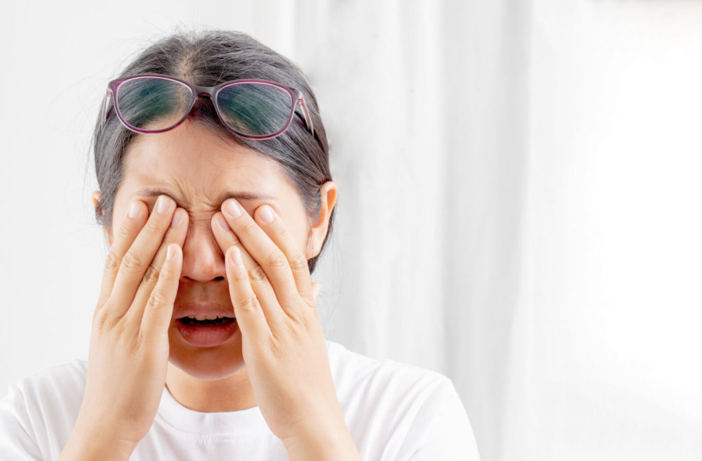 A young woman is irritated rubbing her eyes, she's suffering from blurry poor vision.