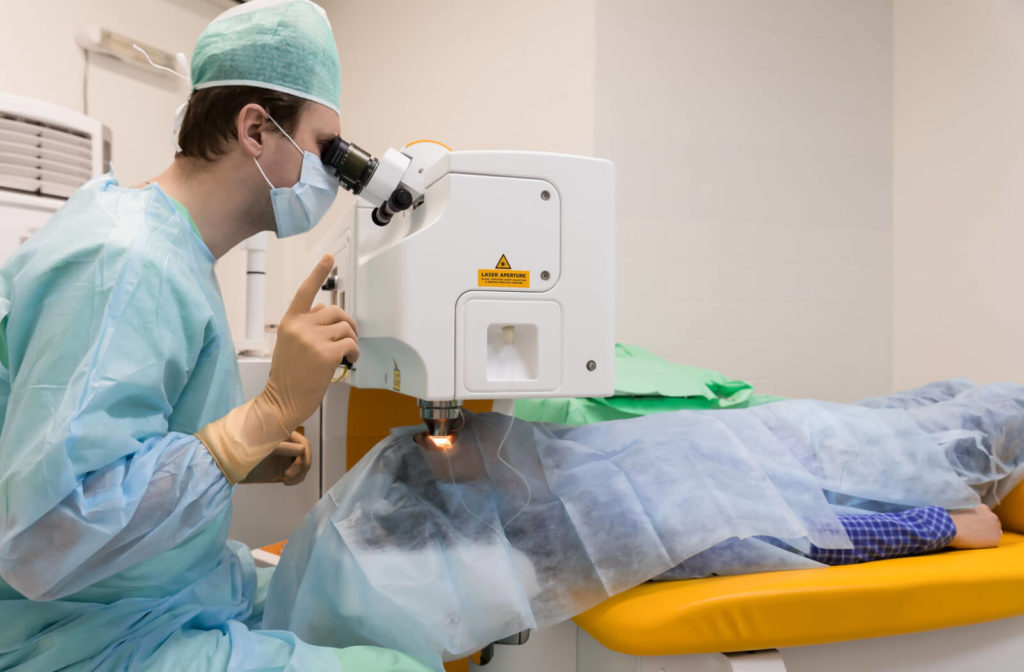 A male ophthalmologist is doing laser therapy to treat floaters on his patient.