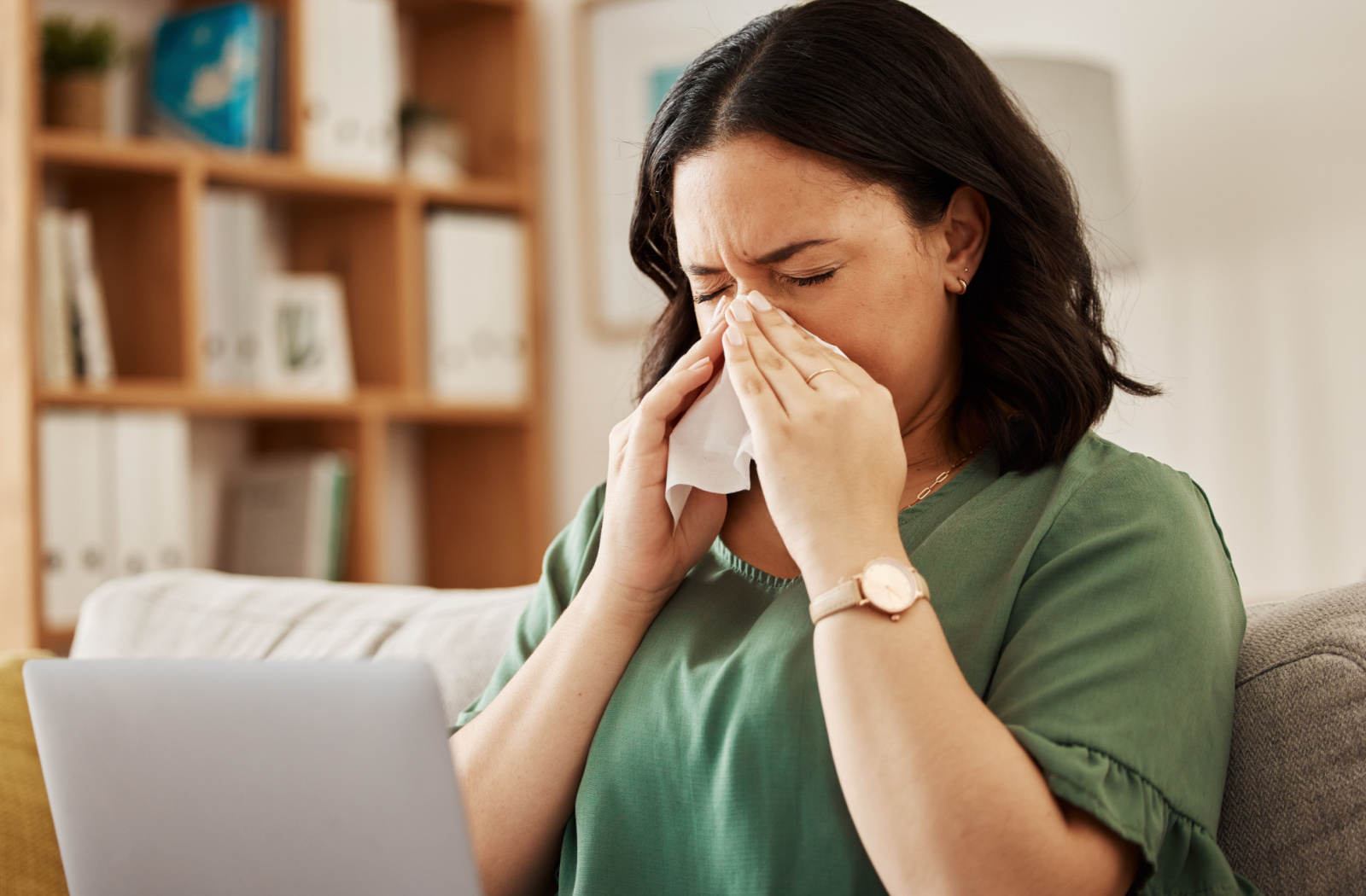 A woman suffering from sinus infections blowing her nose.