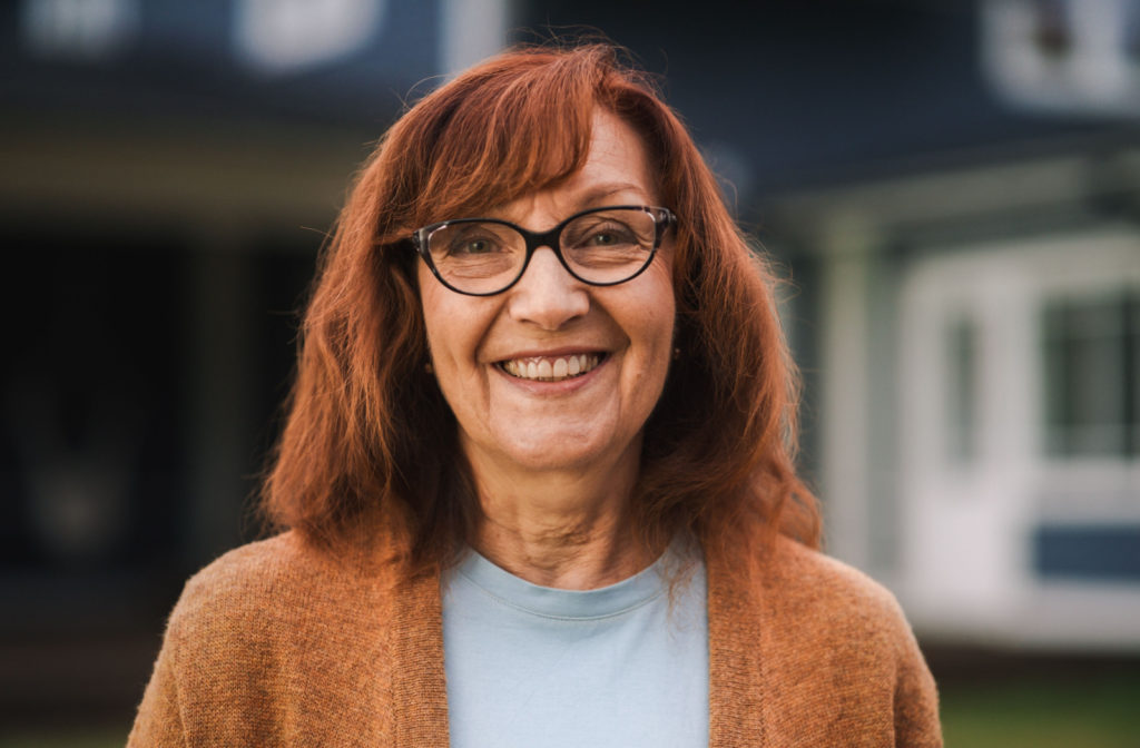 A smiling woman wearing a pair of glasses with progressive lenses.