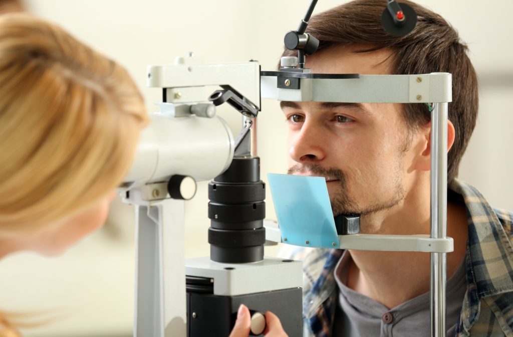 A man undergoing an eye exam to monitor the progression of his keratoconus.