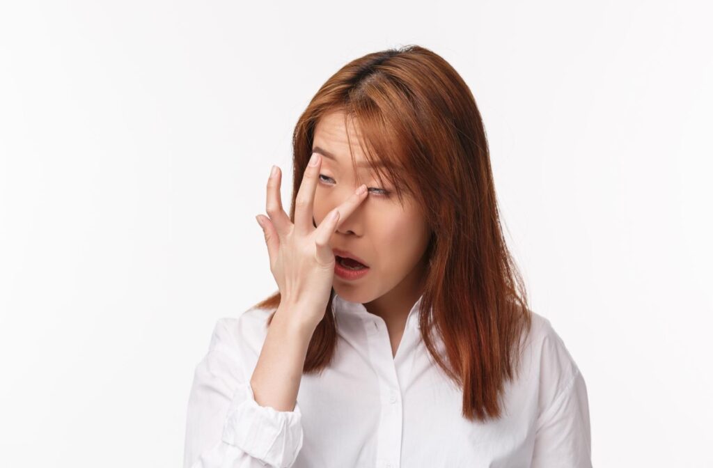 A person rubbing experiencing something in their eye.